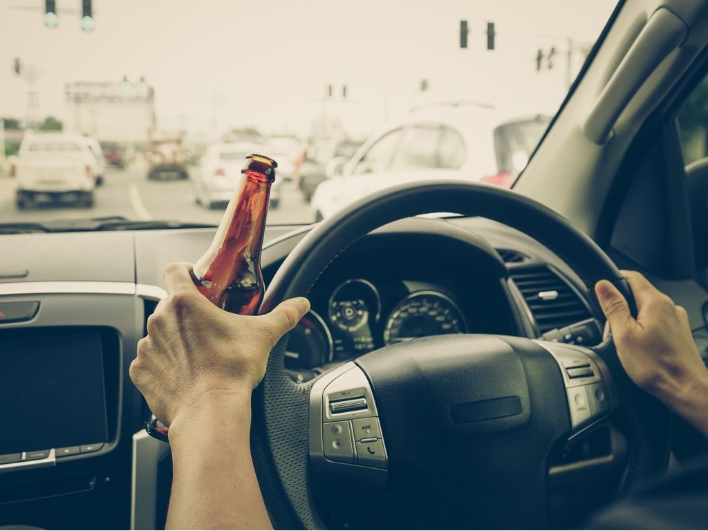 person drinking and driving in traffic