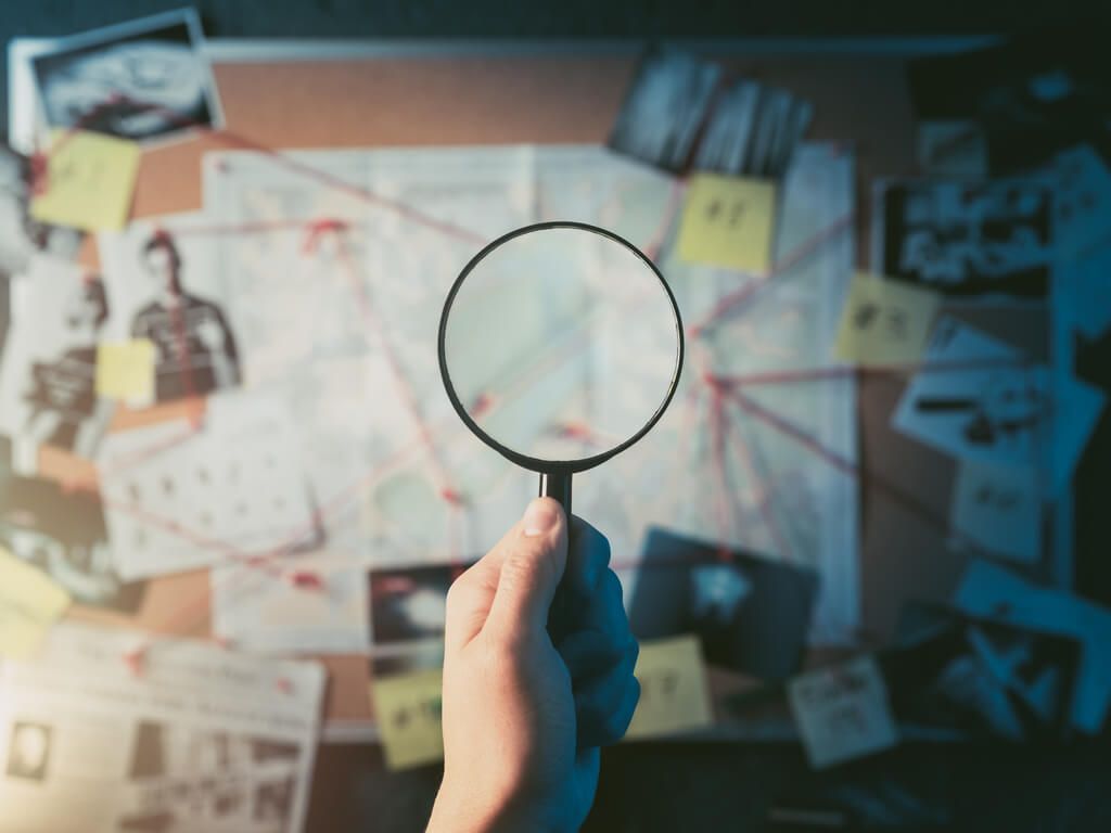 magnifying glass held in front of map and evidence