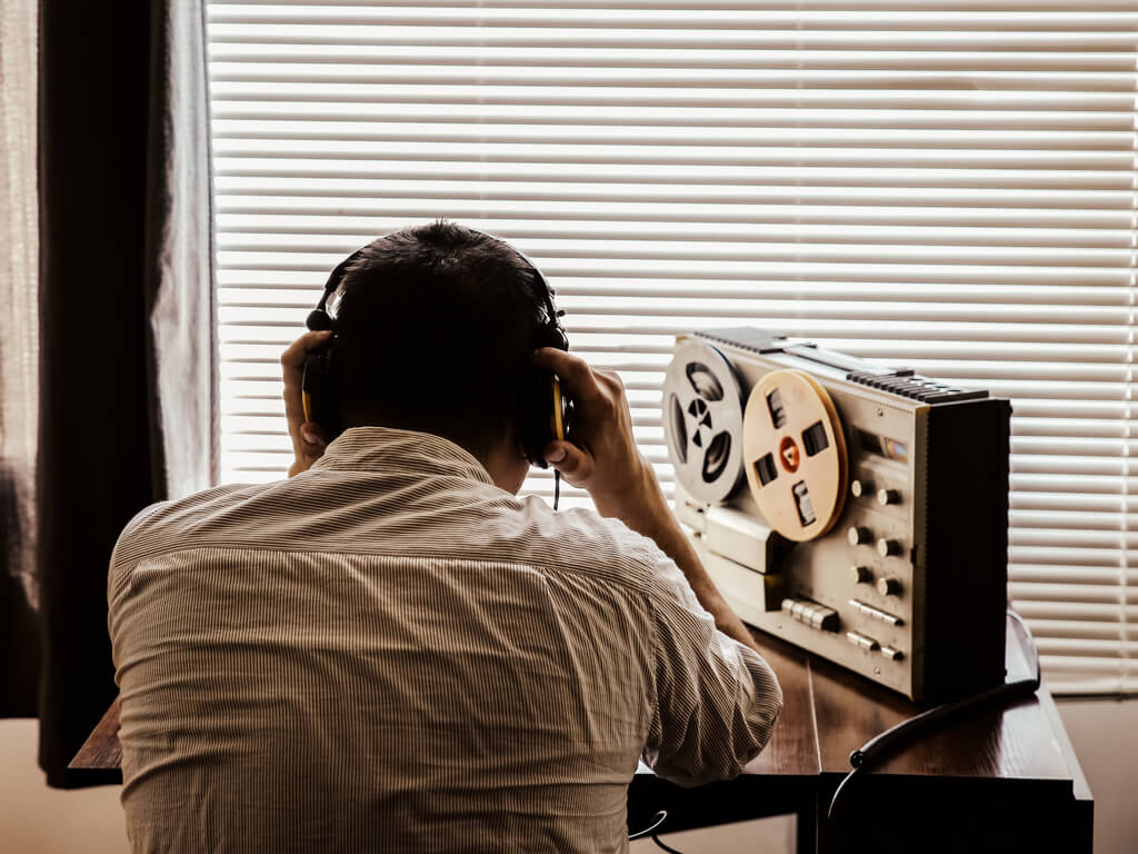 man-sitting-in-front-of-a-recording-machine