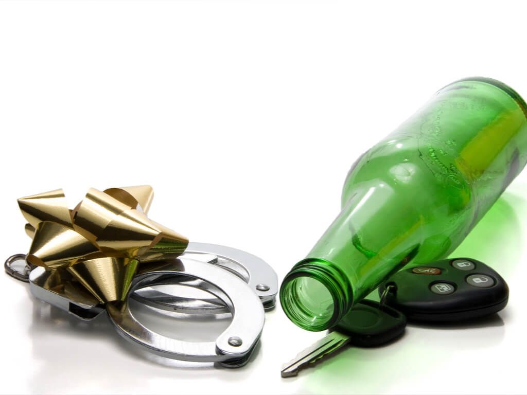 bottle of beer, handcuffs, christmas bow, and car keys piled together