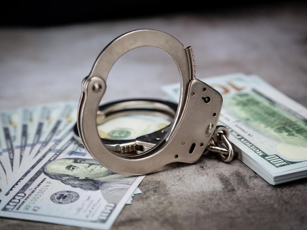 handcuffs laying on a pile of money