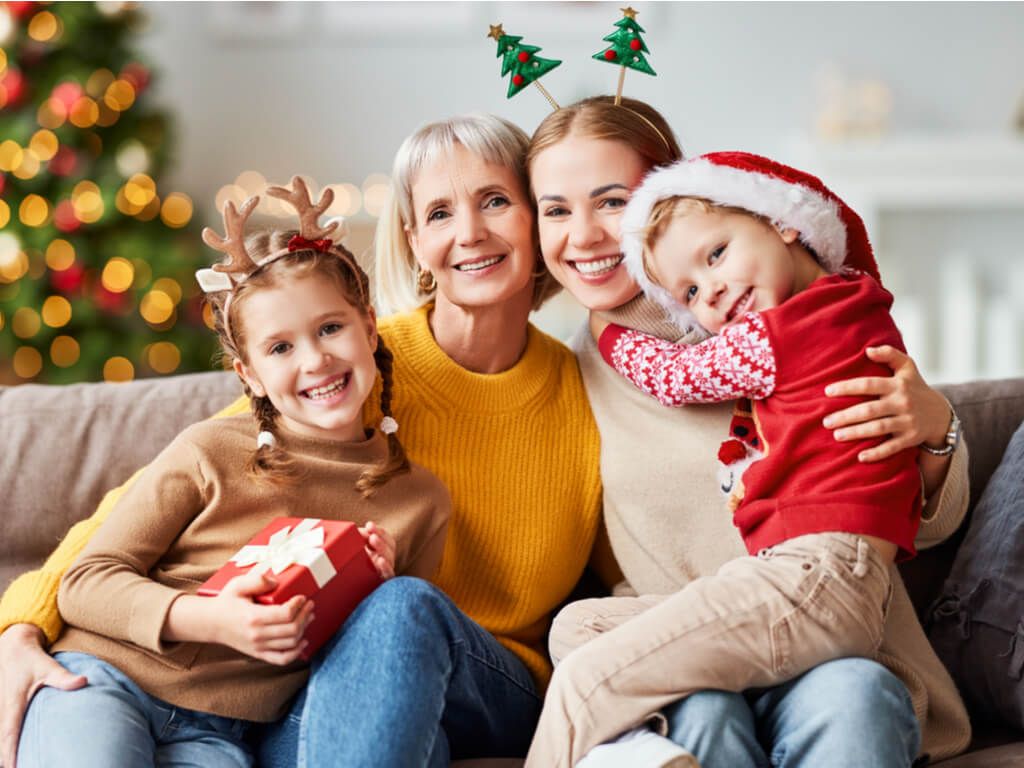 happy family posing in front of the christmas tree