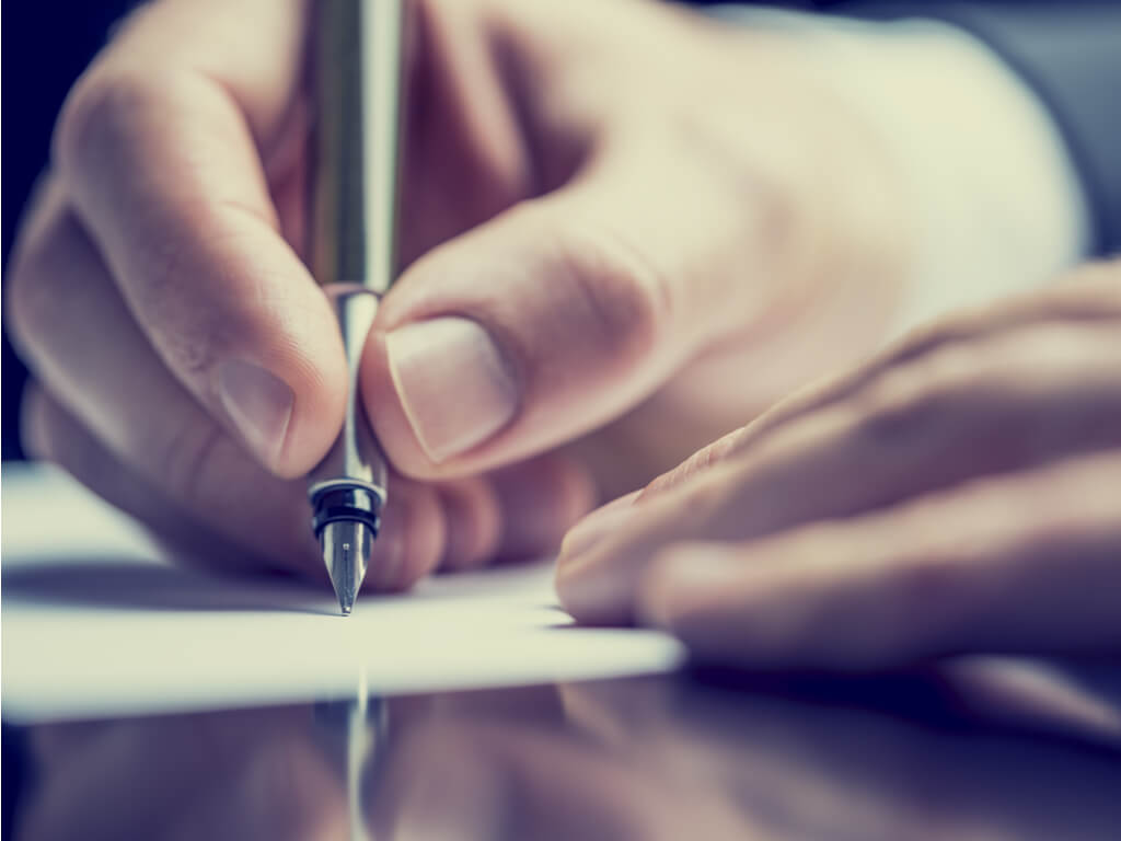 hands signing a document