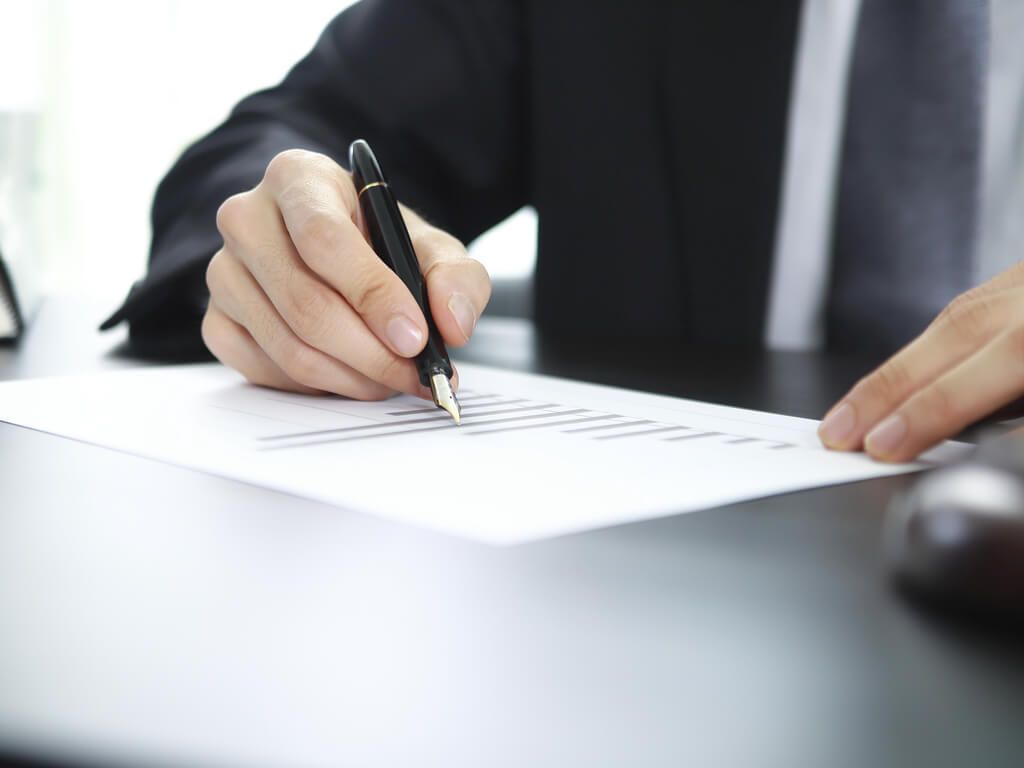 man signing important document such as a trust