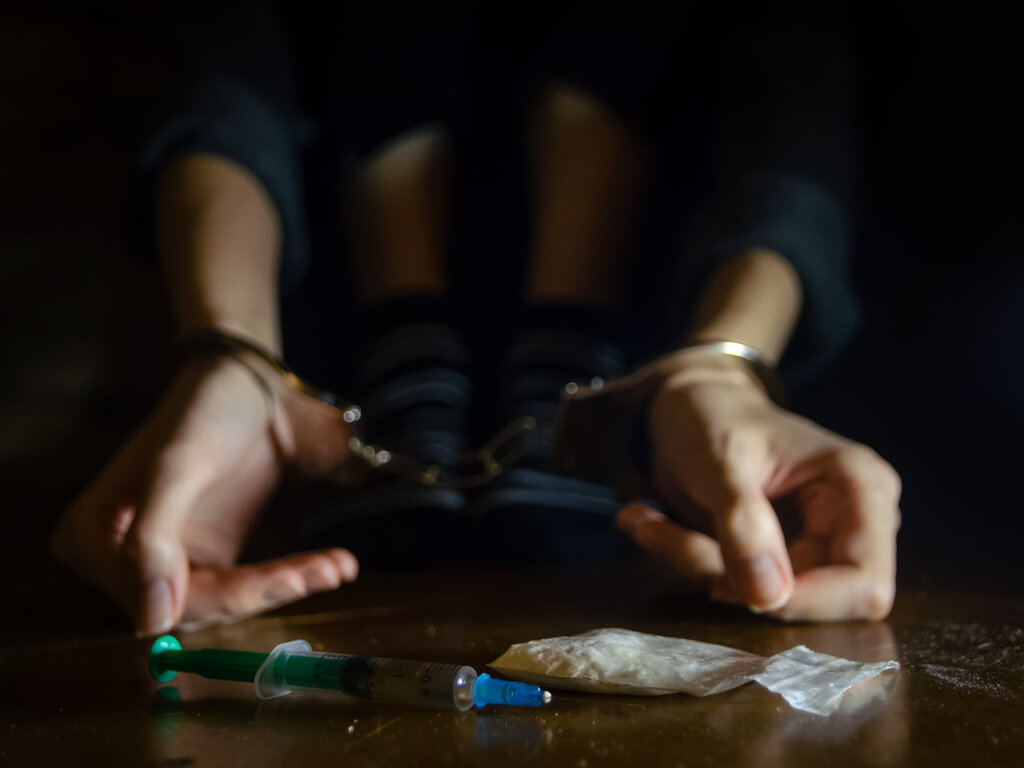 man in possession of illegal drugs wearing handcuffs