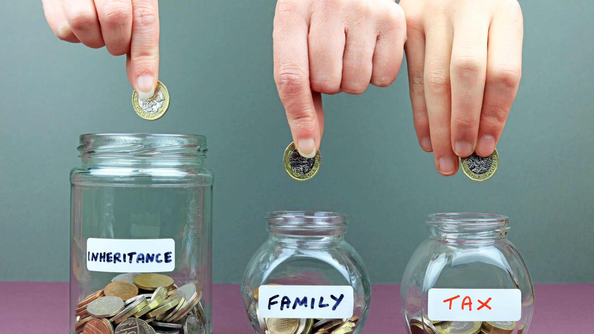 person saving money in jars for inheritance and tax